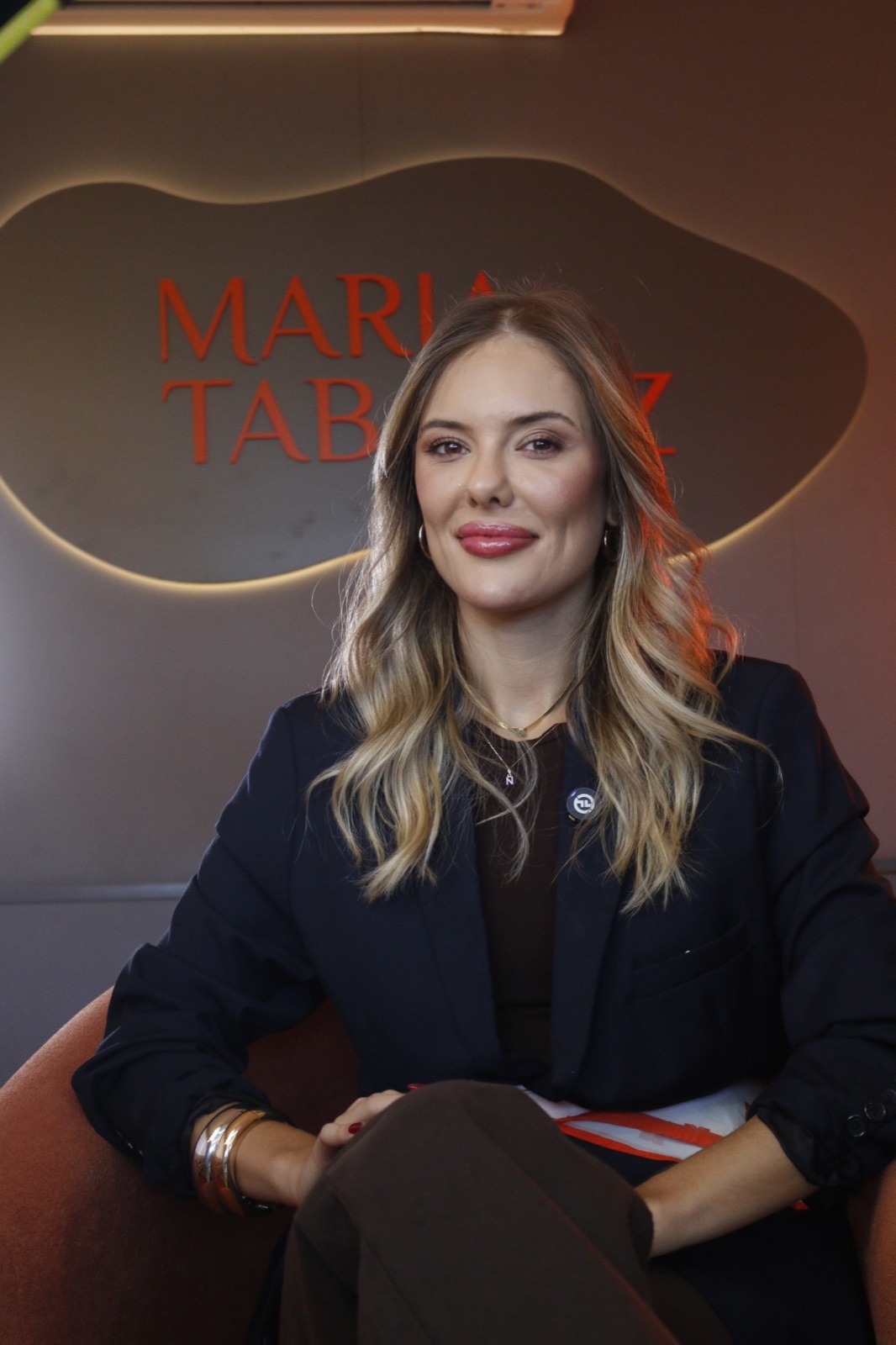 Maria Tabarez, biomédica esteta, sentada em uma poltrona no consultório